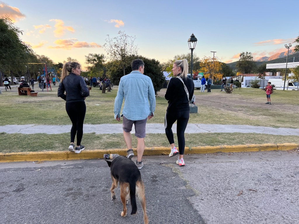 Nicki's friends walk along the street in La Cumbre at sunset