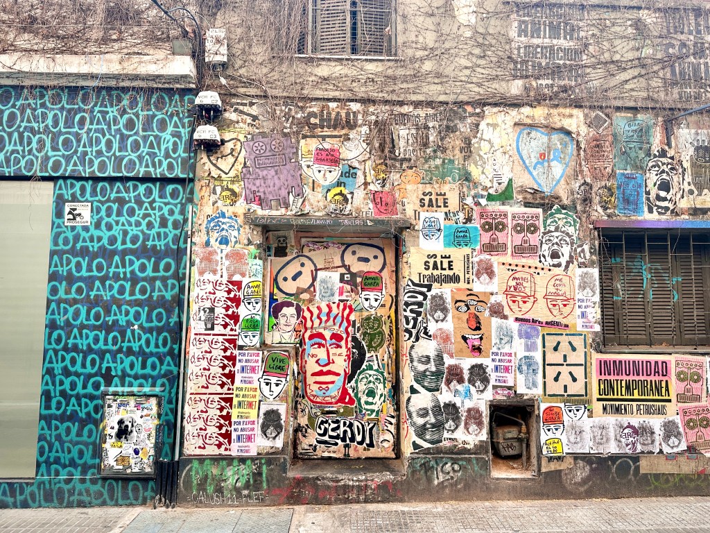 A wall full of graffiti and and posters in Palermo Buenos Aires