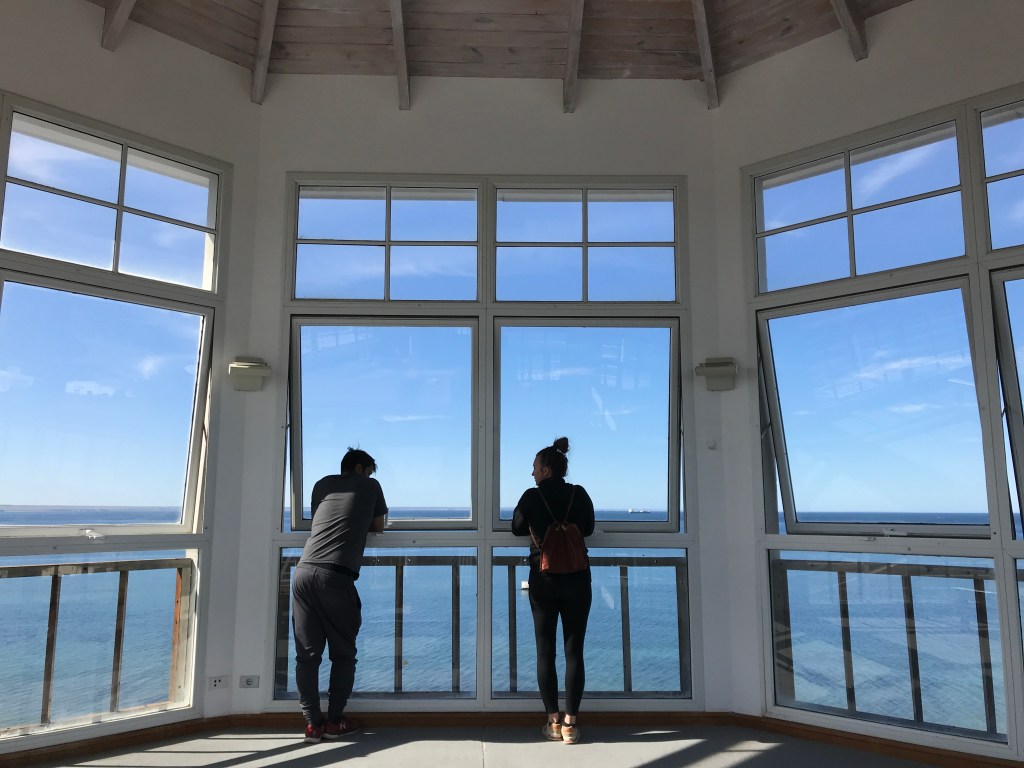 Puerto Madryn: Nicki and Elias stand in front of a large window in the lighthouse at the Ecocentro in Puerto Madryn.