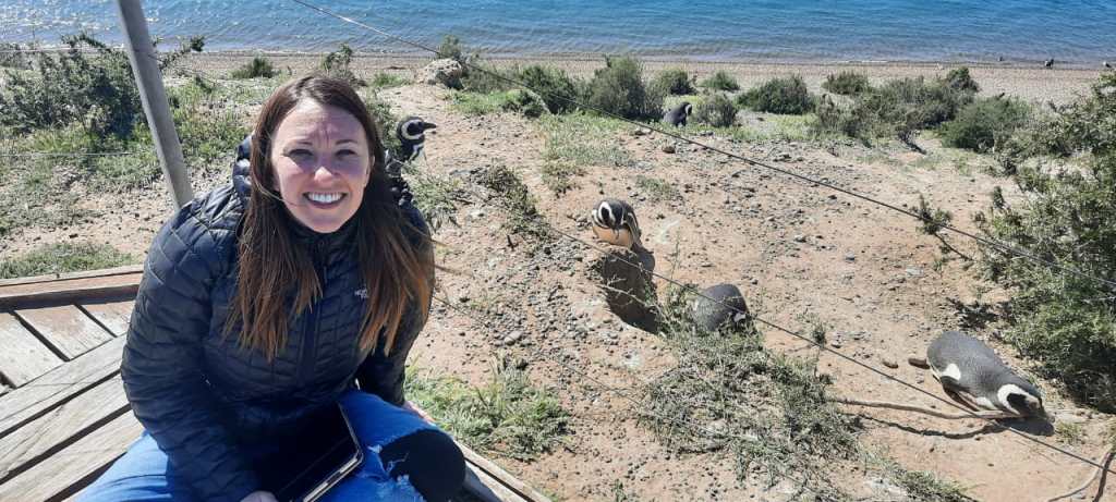 Nicki sits next to some penguins on the peninsula valdes, that is close to Puerto Madryn