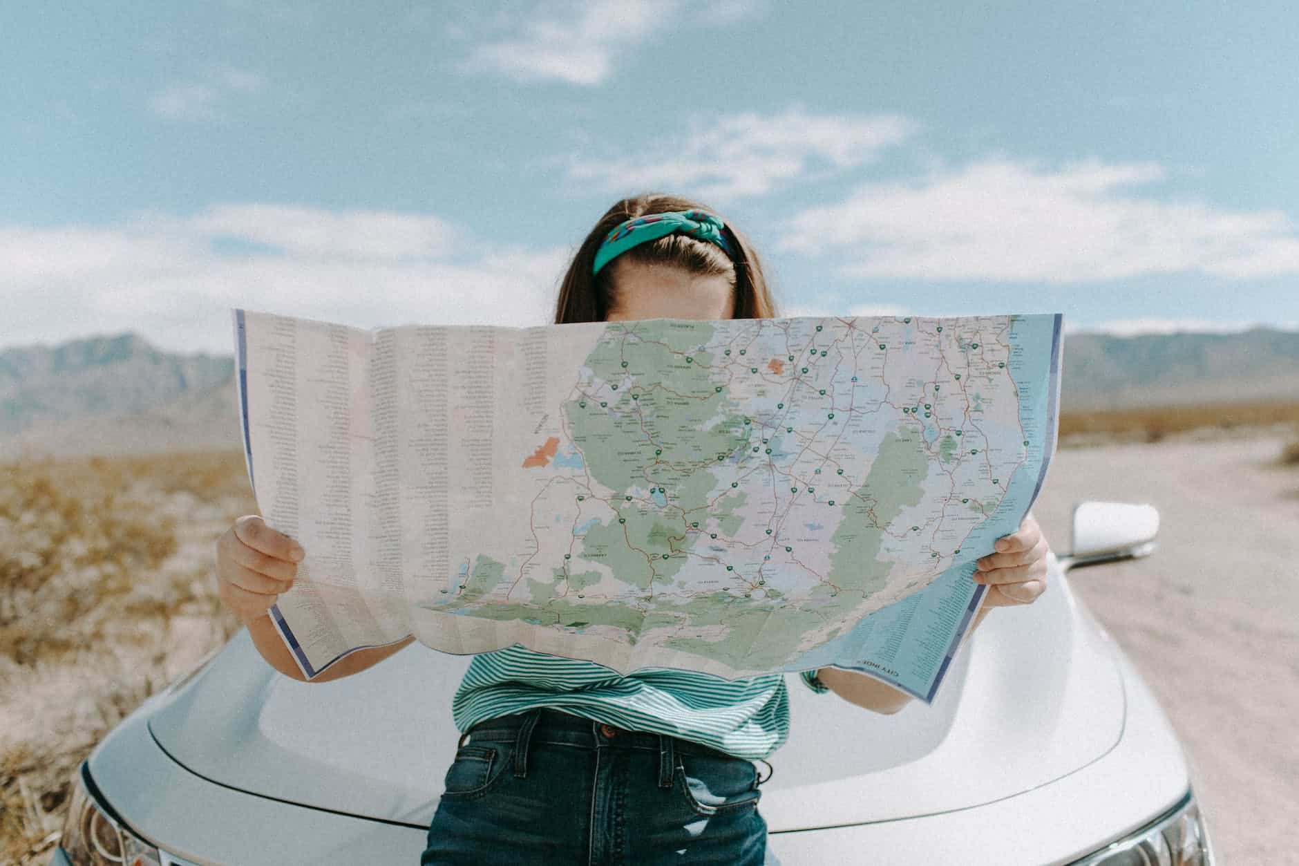 pros and cons of living abroad: woman looking at the map