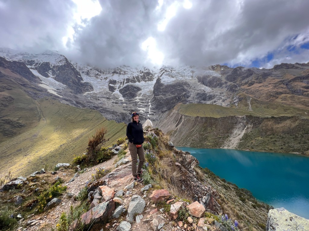 Nicki stands on a cliff above Humantay Lake in Peru