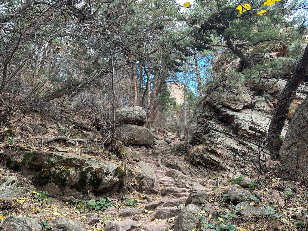 The rocky path along the Amphitheater Trail. There are several rocks and boulders on each side of the trail that is quite steep.