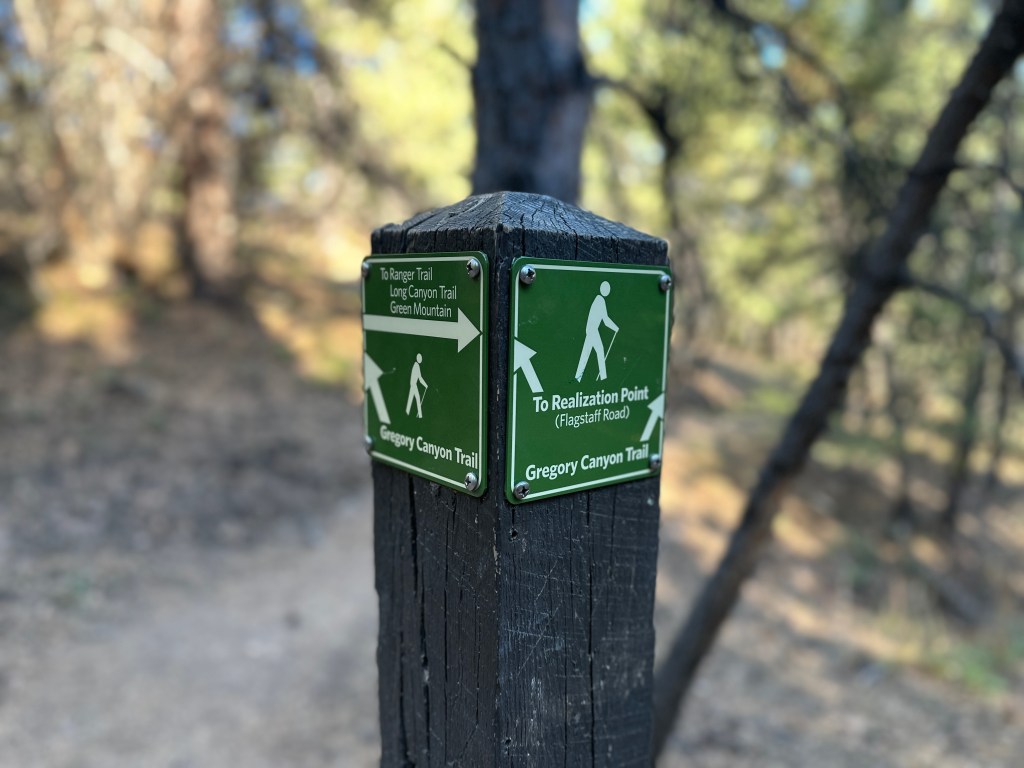 A trail sign at the junction of Ranger Trail and Gregory Canyon Trail. You can also see the arrow pointing left for Realization Point.
