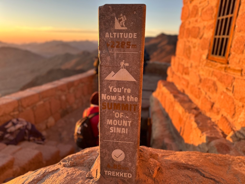 After hiking Mt Sinai, you reach the peak and there are a few structures. This sign marks the summit and is next to the mosque.