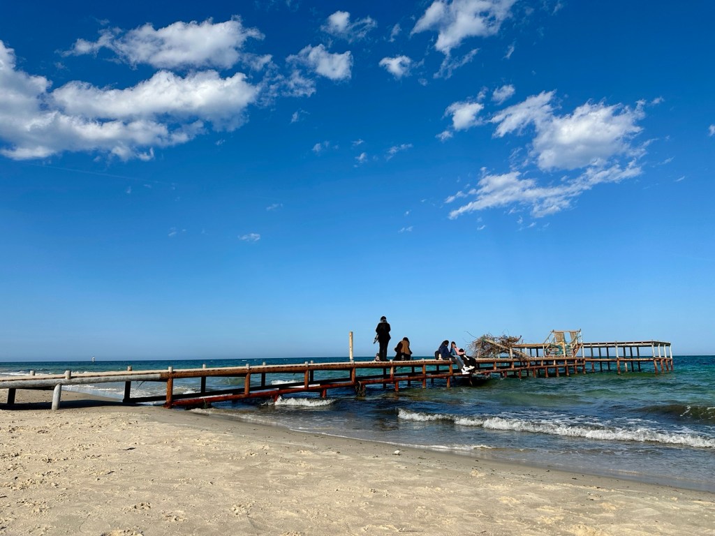 The beaches of Tunisia. This beach is in Sousse. There is a wharf that goes out into the water and children jump off.