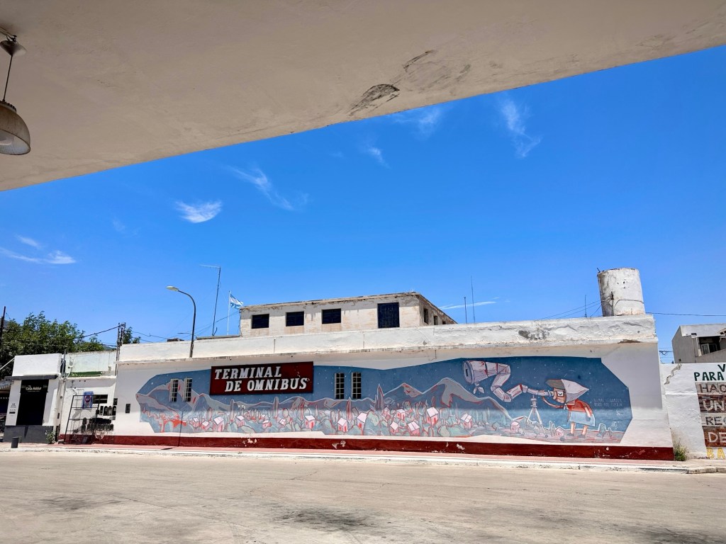 The bus terminal in Capilla del Monte. There is a mural with an alien painted on the wall.